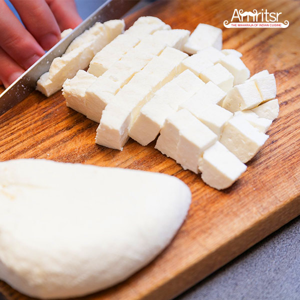 Cubes of Paneer on a chopping board